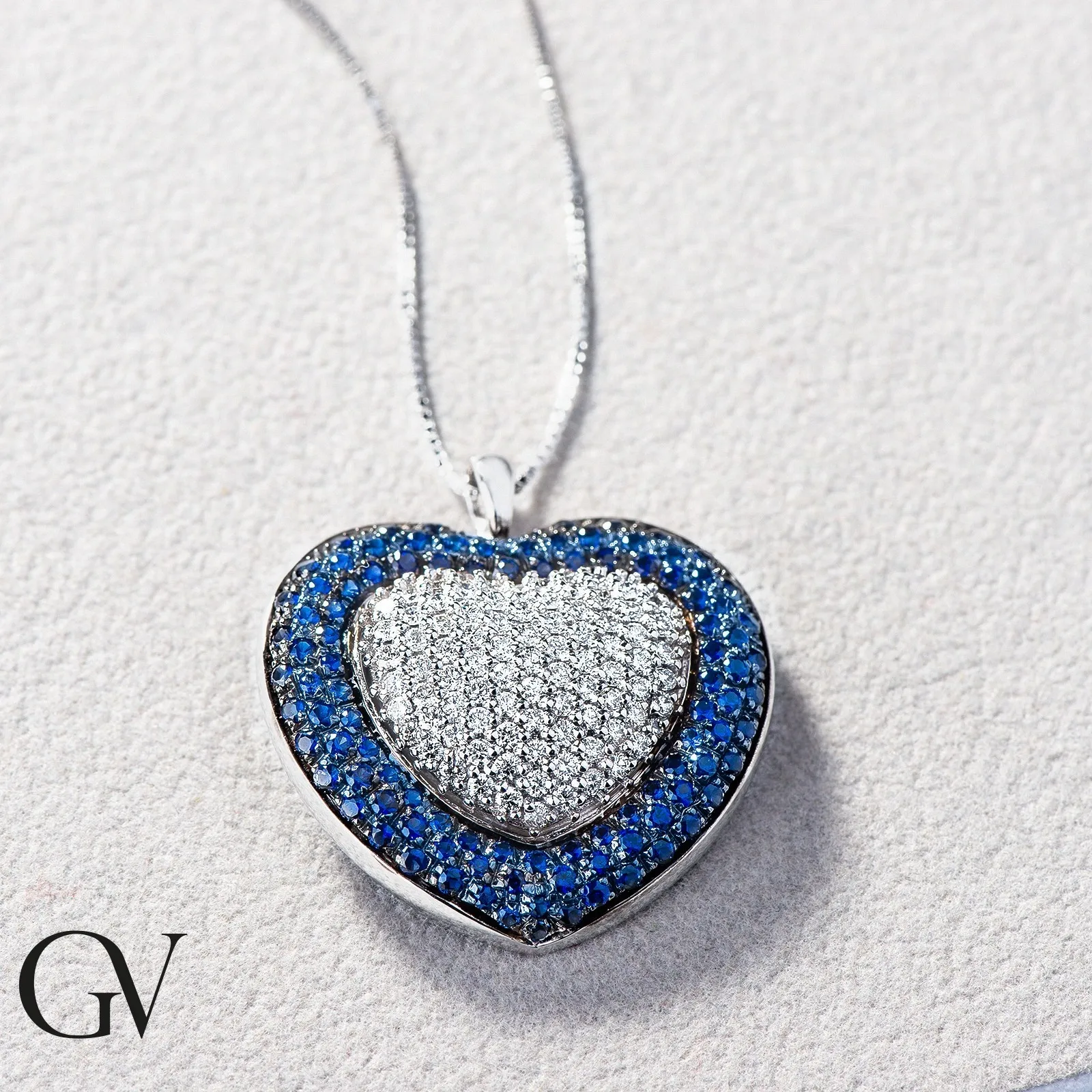 Collana in oro bianco 18k con ciondolo a cuore in diamanti e zaffiri blu